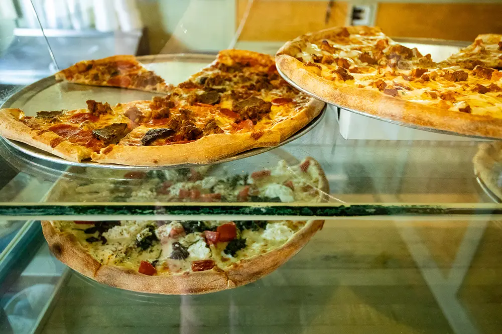 Gourmet pizzas in a display case.